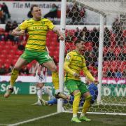 Norwich City duo Ashley Barnes and Borja Sainz celebrate in front of the away end at Stoke
