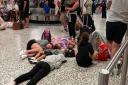 Wish you were here? Children lying on the floor at Birmingham's airport during a delay from Norwich Airport