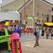 A half-and-half scarf seller outside of Carrow Road as fans arrive for the game against Liverpool